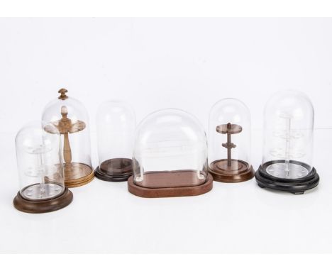 Six small modern presentation stands under domes, two glass domes, one oval glass dome, tallest 24cm, and three with glass do