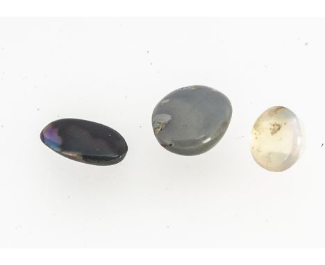 Two oval polished black opals, together with a circular polished precious white opal, just over 1cts 