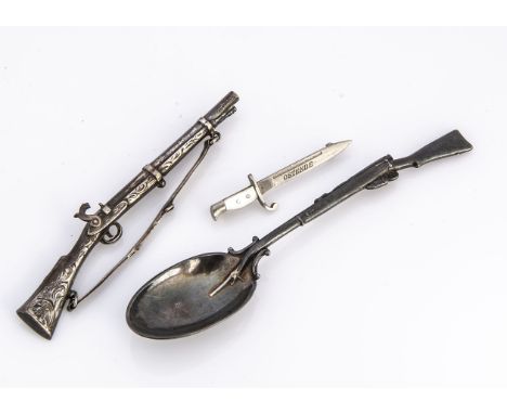 A vintage flintlock rifle brooch, together with a silver plated rifle teaspoon and a dagger brooch marked Ostende (3) 