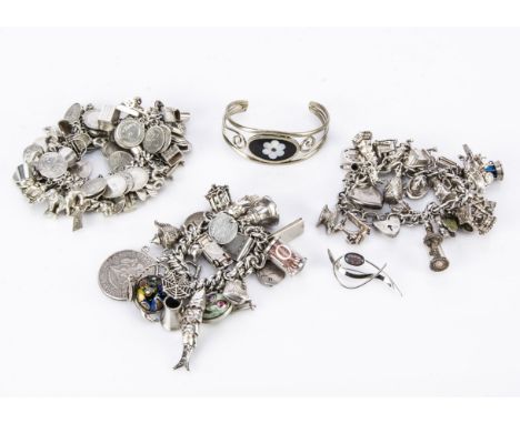 A collection of three charm bracelets, including a one with coins and spinning charm, another with a miners lamp, three leaf 