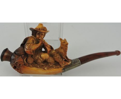 A 19th century German Meerschaum cheroot holder, finely carved with a seated boy playing a pipe, with attendant hound, white 