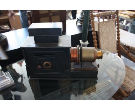 A Victorian black tinplate magic lantern with rectangular chimney & copper/brass lense, L.52cm
