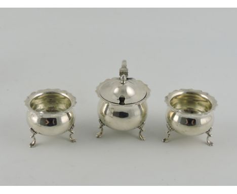 A silver three-piece cruet set, Chester 1917, comprising two cauldron shaped salts, with ogee lip, raised on tripod pad feet 