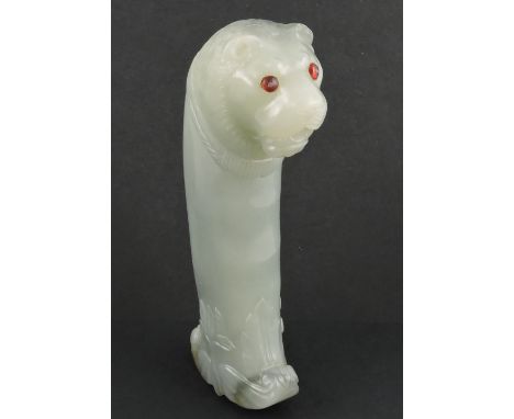 A 19th Century Mughal carved grey jade dagger handle, the terminal finely carved with a lion's head with red gem set eyes, th