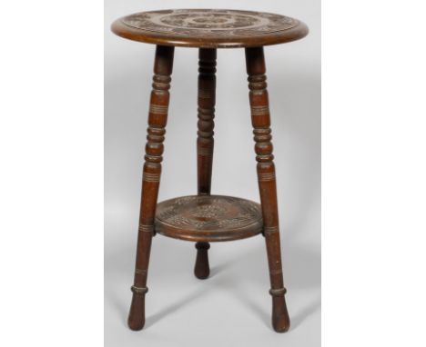 A Victorian carved wood two tier occasional table, late 19th century, carved with fan shaped and star shaped ornament, with l