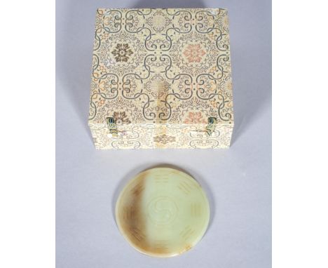 A Chinese carved pale jade disc and carved hardwood stand, 20th century, carved with radiating calligraphic inscription and Y