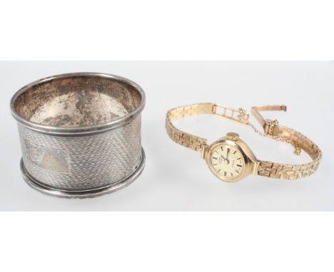 A hallmarked 9ct gold mechanical Rotary wristwatch together with a 25.0mm napkin ring. Gross weight: 29.0 grams