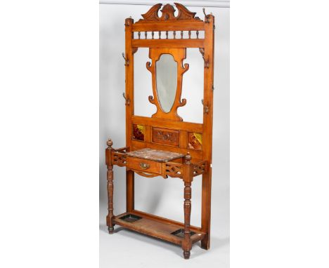 A late Victorian walnut hall stand, with architectural cornice shield shaped bevel glass mirror, marble insert and glove draw