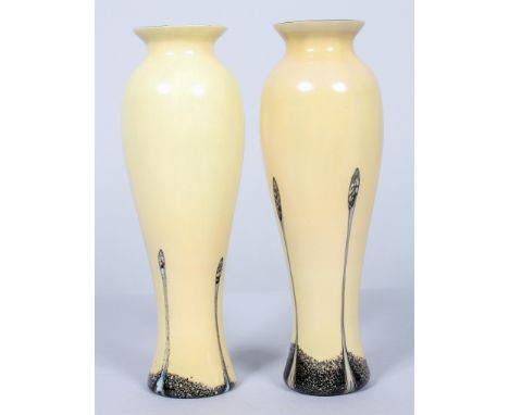 A pair of Caithness cased baluster glass vases, with cream surface and streaked in black and cream marbled trailing, with bla
