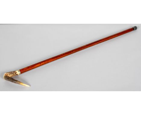 A carved horn mounted crook walking stick, circa 1900, the horn handle with metal collar, on turned wooden walking stick, 86c