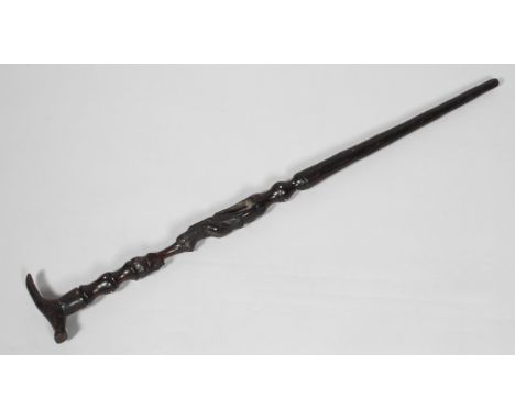 A 20th century African walking stick, the shaft carved with a seated figure with bone inlay, 80cm long