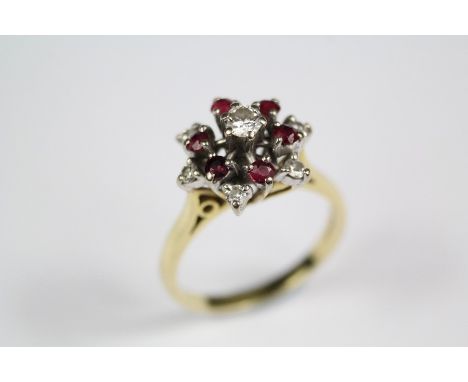 An 18ct white and yellow gold ruby and diamond ring, set with center diamond approx 14 pts, 6 x 2.5 rubies and 5 x 2.5 pts of