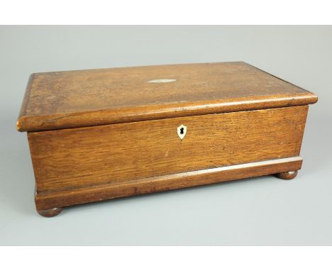 A 19th century oak storage box, on bun feet, with a mother of pearl cartouche, approx 24 x 42 x 16 cms.