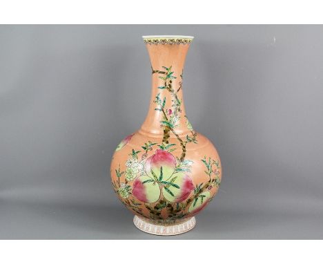 A Chinese Famile Rose Bottle Vase; the vase having a peach coloured ground with peach blossoms and fruit, Kangxi marks to bas