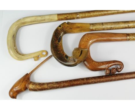 Four hand-carved walking sticks; including a stick with horn-handled trout handle, two "shepherd's crook" sticks and lastly a