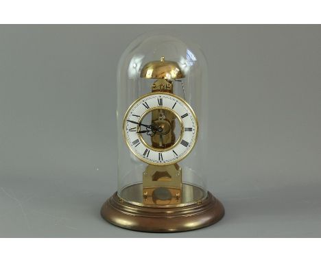 A German Hermle skeleton table clock, the brass clock having a white enamel face with Roman dial, strikes to a bell under a g