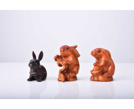 A group of three Japanese carved wood netsuke of rabbits, 20th centuryEach naturalistically modelled and inset with horn eyes