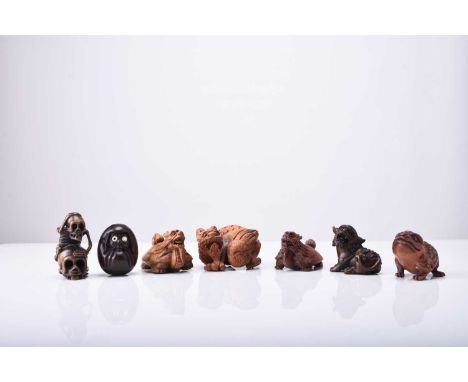 A group of seven Japanese wood netsuke of mythical creatures, 20th centuryIncluding a demon mask, a coiled dragon, a Jin Chan