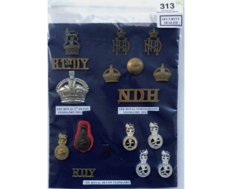Card of Royal 1st Devon, North Devon Yeomanry and Royal Devon Yeomanry insignia.A good selection of cap badges, collars, butt