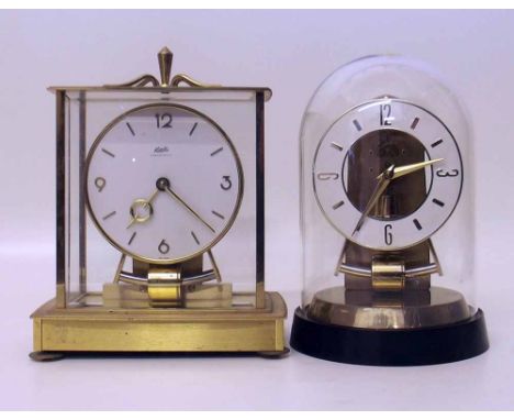 Two Kundo batter electro-magnetic mantel clocks. A condition report is not available for this lot.  Damage, defects, restorat