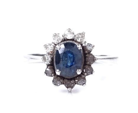 An 18ct white gold sapphire and diamond cluster ring, oval-cut sapphire approx 0.71ct, setting height 11.5mm, size M, 3.1g 