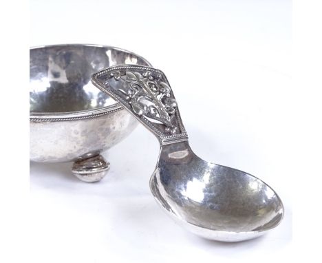 An Arts and Crafts silver caddy spoon and bowl, with pierced stylised floral handle, unmarked but possibly C R Ashbee or Edwa