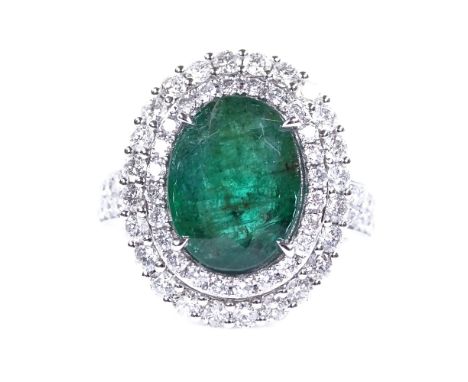 An 18ct white gold emerald and diamond cluster cocktail ring, with diamond set shoulders, oval-cut emerald approx 3.7ct, tota