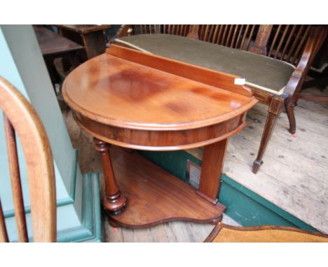 Semi-circular mahogany hall table with turned front leg and low shelf on bun feet