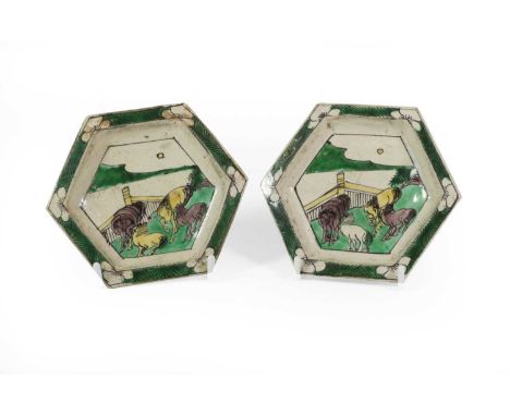 A Pair of Chinese Sancai Porcelain Hexagonal Dishes, Kangxi, each painted with four horses in a fenced garden within a foliat