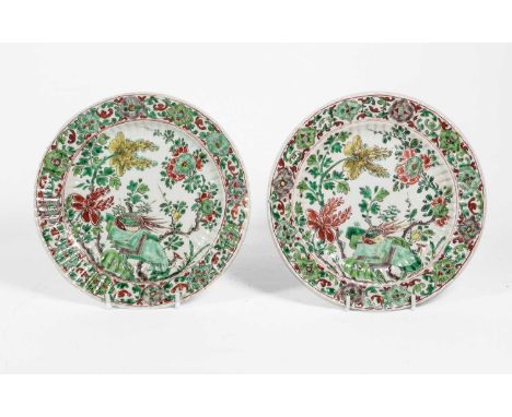 A Pair of Chinese Porcelain Plates, Kangxi, of fluted circular form, painted in famille verte enamels with peacocks amongst f