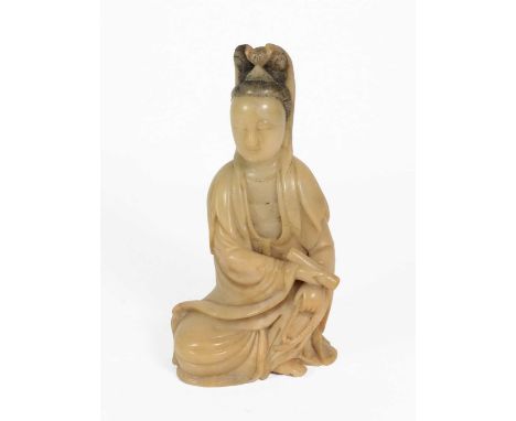 A Chinese Soapstone Figure of Guanyin, Qing Dynasty, 18th century, carved seated with hair up, holding a scroll and beads, 18
