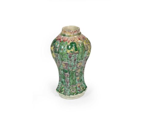 A Chinese Porcelain Vase, Kangxi, of fluted oval section baluster form, painted in famille verte enamels with panels of folia