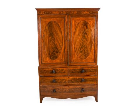 A Regency Mahogany, Tulipwood Banded and Ebony Strung Clothes Press, early 19th century, the moulded cupboard doors with oval