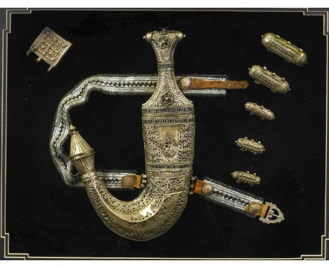 A 20th Century Arab Presentation Jambiya, with silver coloured metal filigree decorated hilt and scabbard, lace belt and fitt