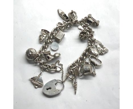 Vintage silver loaded charm bracelet with charms Stamped sterling silver on heart padlock clasp and charms. Approx. 18cm long