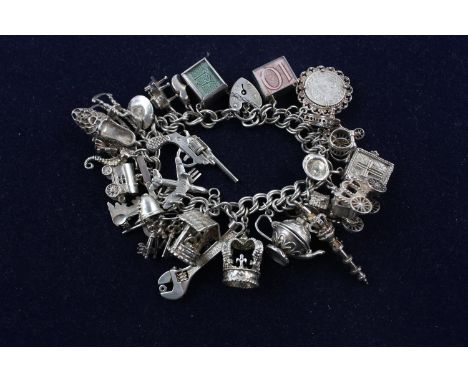 Silver charm bracelet with charms Assay stamps for London 1975. Stamps both on padlock clasp and end link. Approx. 16cm long 