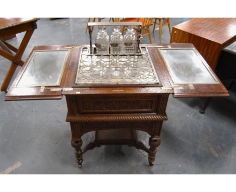 Carved oak drinks cabinet by Maple &amp; Co., with two divisions to the top opening to reveal a rise and fall interior with m