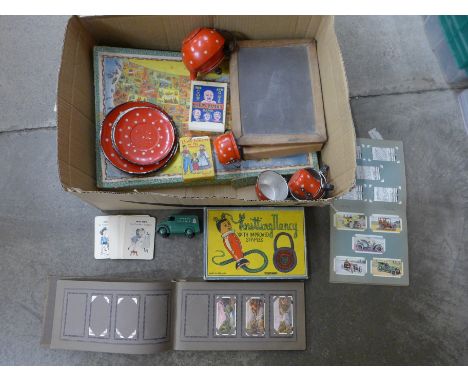 A collection of 1950's toys, includes a child's polka dot tea set, chalk board, Happy Families playing cards, a Dinky Toys Tr