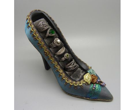 Six silver and marcasite rings on a shoe shaped ring stand 