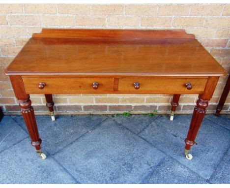 A VICTORIAN MAHOGANY SIDE TABLE  fitted with two drawers on fluted supports with ceramic casters, 122cm wide 53cm deep 80cm h