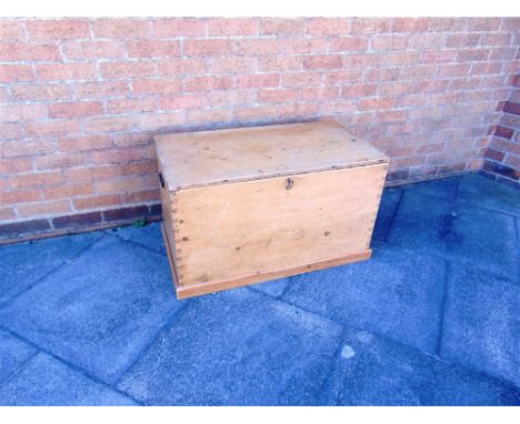 A PINE TRUNK OF DOVETAILED CONSTRUCTION with carrying handles, 91cm wide 51cm deep 53cm high