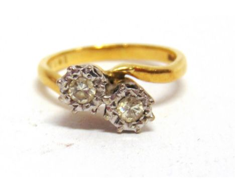 A TWO STONE CROSSOVER 18 CARAT GOLD RING  the illusion set brilliant cuts totalling approximately 0.2 carats, finger size K, 