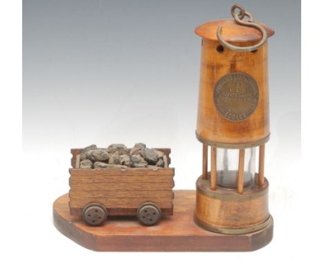 Mining Treen - a 20th century beech desk stand, as a miner's lamp and coal truck, the lamp with hanging hook and brass badge 