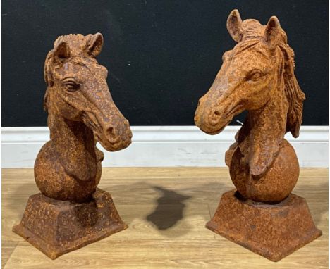A pair of cast iron gate post or wall finials in the form of horse heads, square bases, the larger 45cm high, the smaller 43.