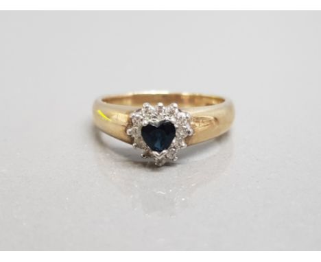 Ladies 9ct yellow gold sapphire and diamond heart shaped ring featuring a blue heart in the centre surrounded by 12 round bri