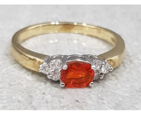 Ladies 9ct yellow gold fire opal + diamond ring, featuring an oval shaped fire opal set in the centre with 3 round brillaint 