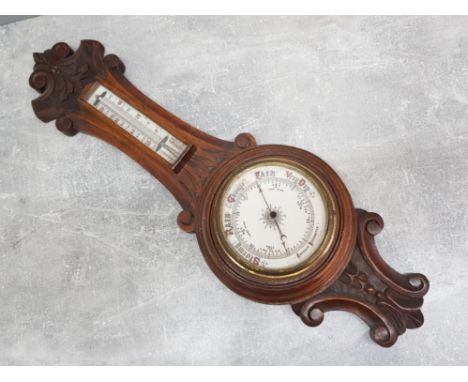 A Victorian oak cased aneroid barometer, scroll crested rail above thermometer and barometer dial, 62cm High