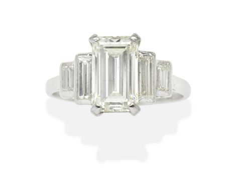 DIAMOND RINGThe step-cut diamond weighing 2.65 carats between baguette-cut diamonds, ring size approx. K½ (hoop off-round)For