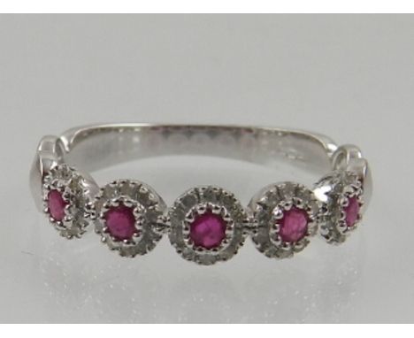 A 9 carat white gold, diamond and ruby half eternity cluster ring. 