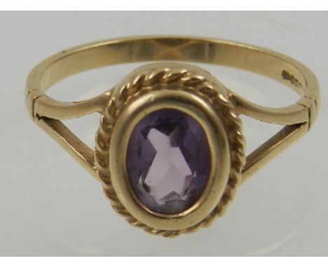 A 9 carat yellow gold and amethyst ring in a rope twist mount. 